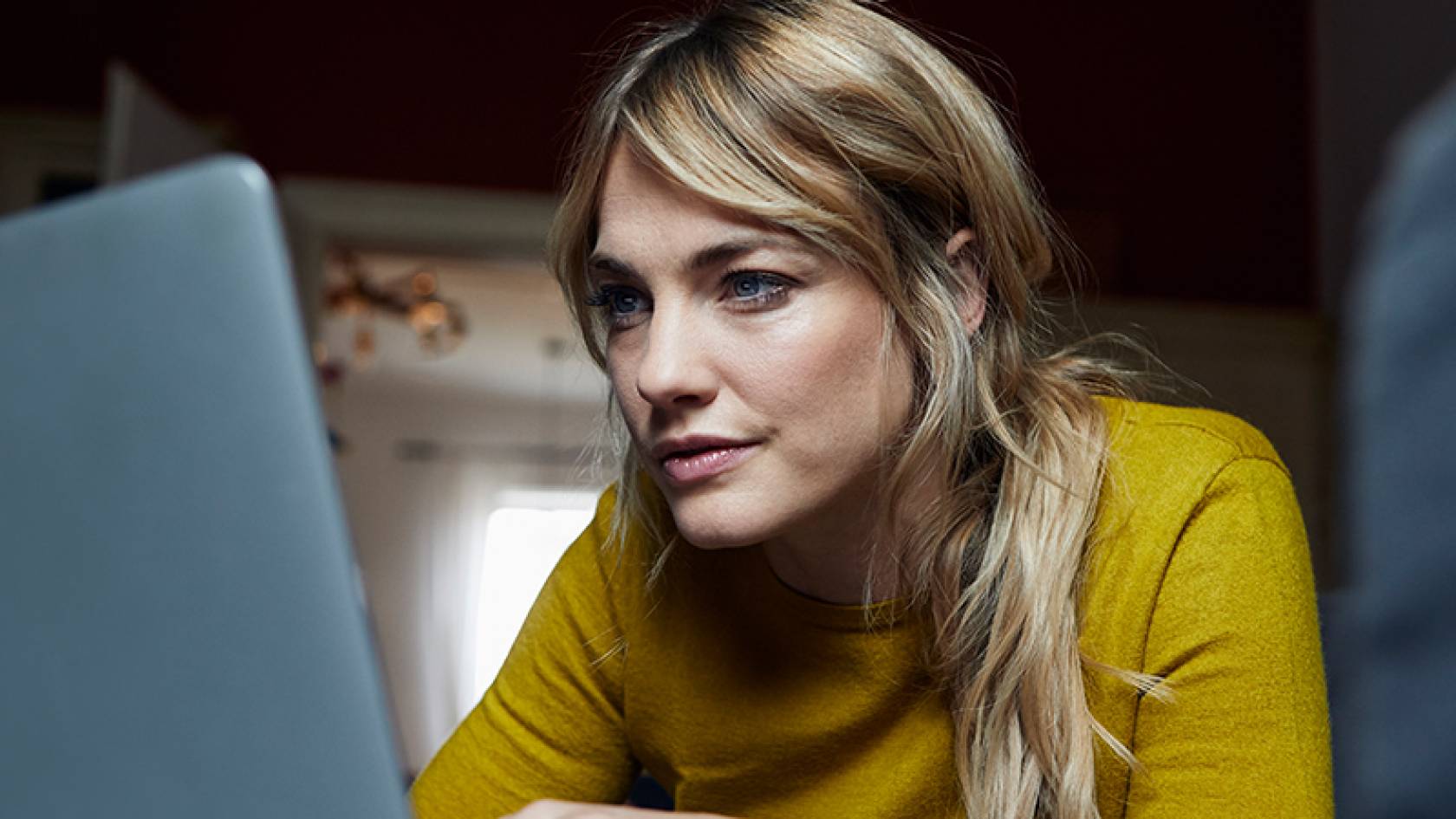 Schmuckbild Operative Personaleinsatzplanung Frau sitzt am Schreibtisch und arbeitet mit einem Laptop